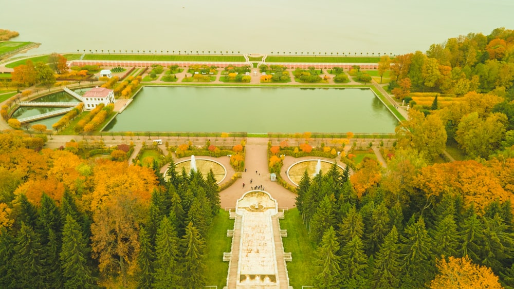 an aerial view of a garden with a pond in the middle