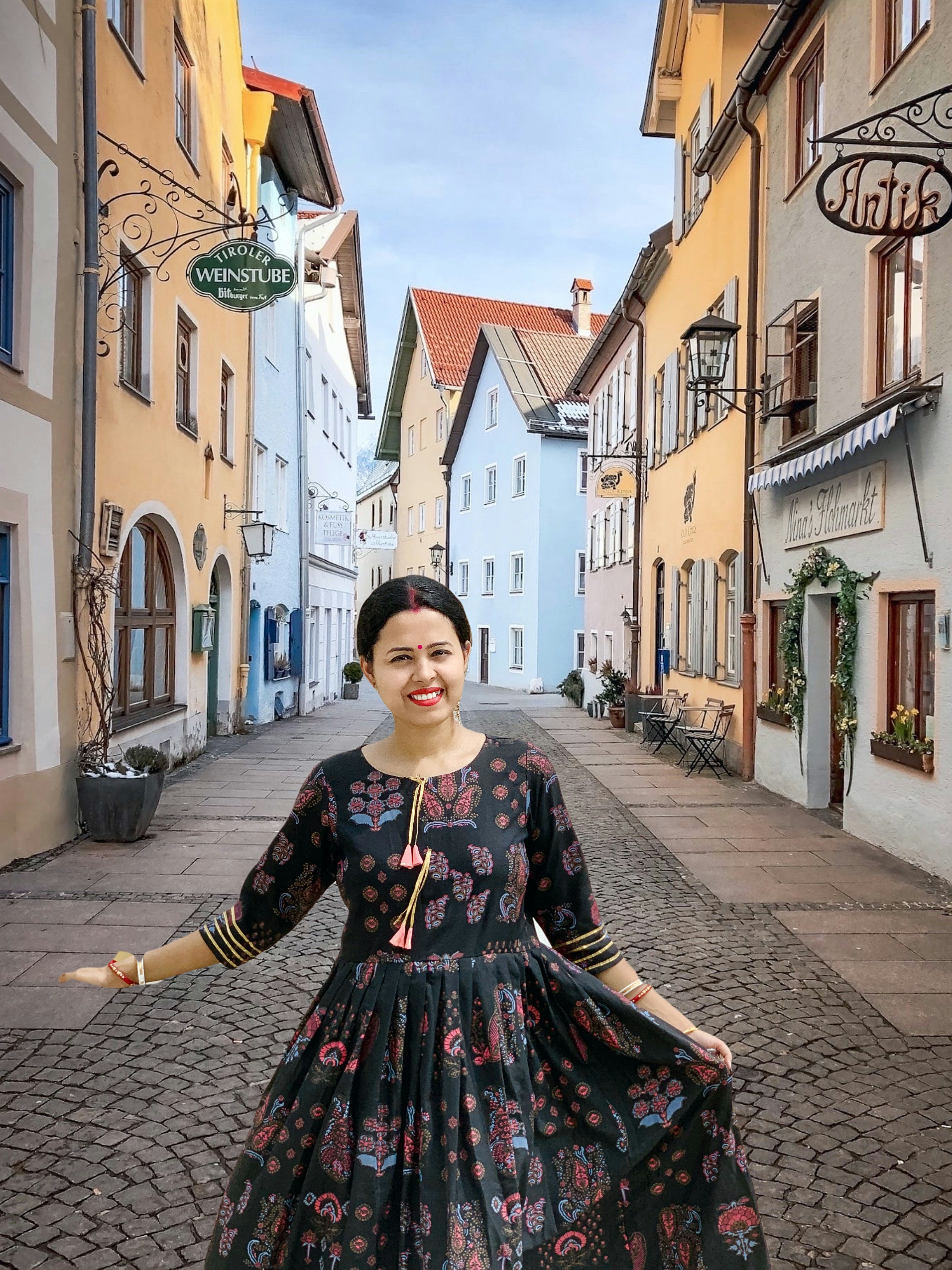 A woman in a black dress standing on a cobblestone street photo – Free ...