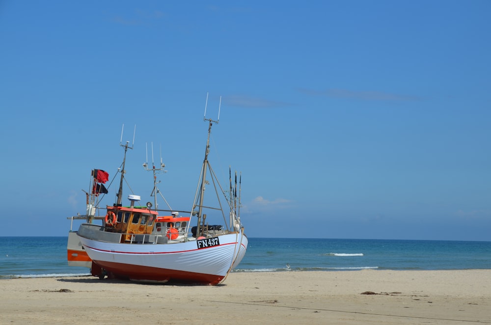 um barco sentado no topo de uma praia de areia