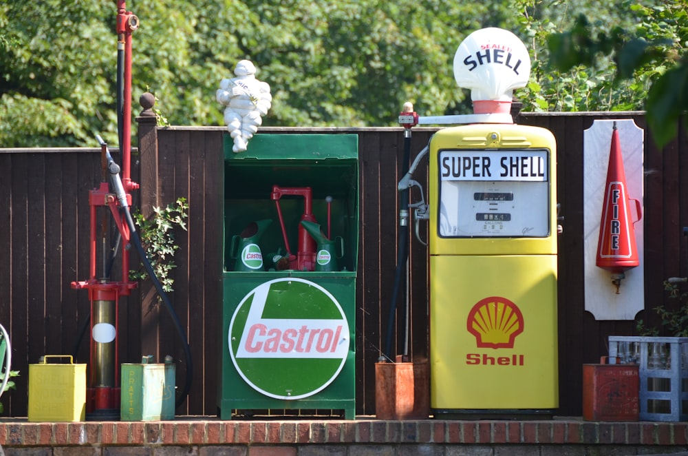 a gas pump sitting next to a wooden fence