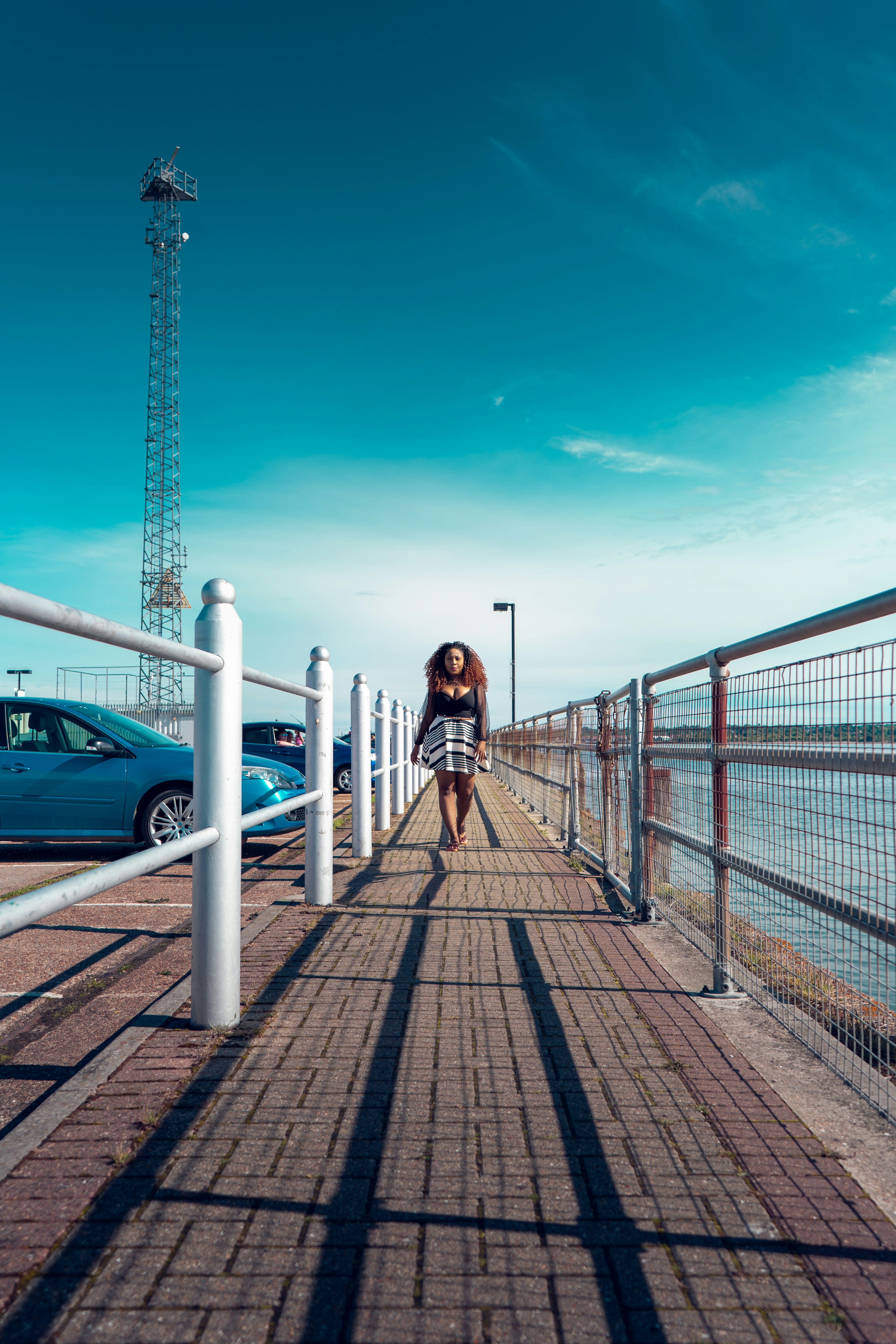 Une femme marchant sur un trottoir au bord de l’océan