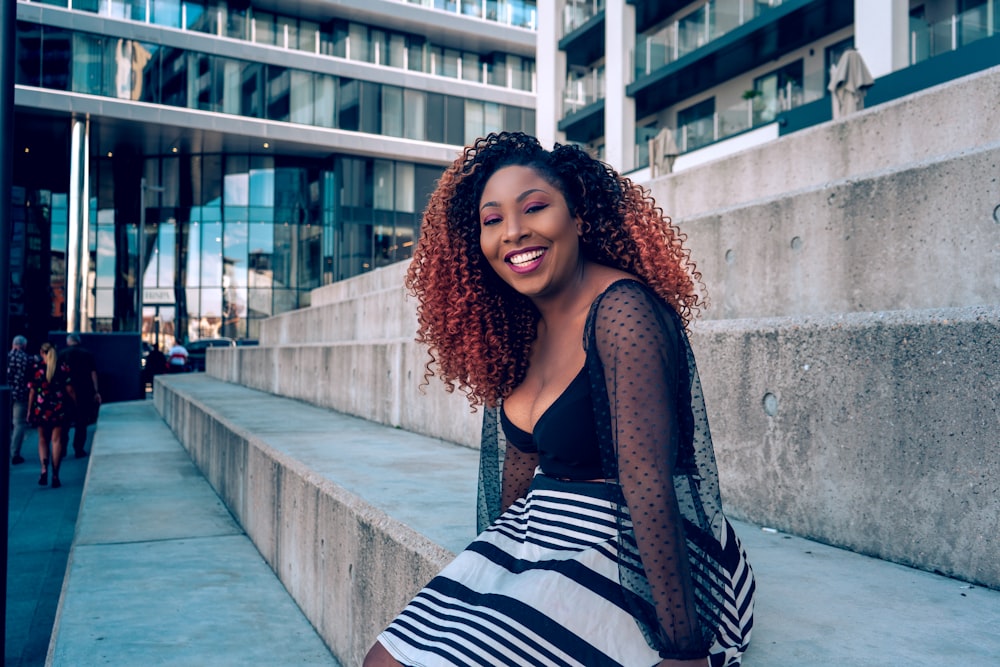 a woman with red hair is sitting on some steps