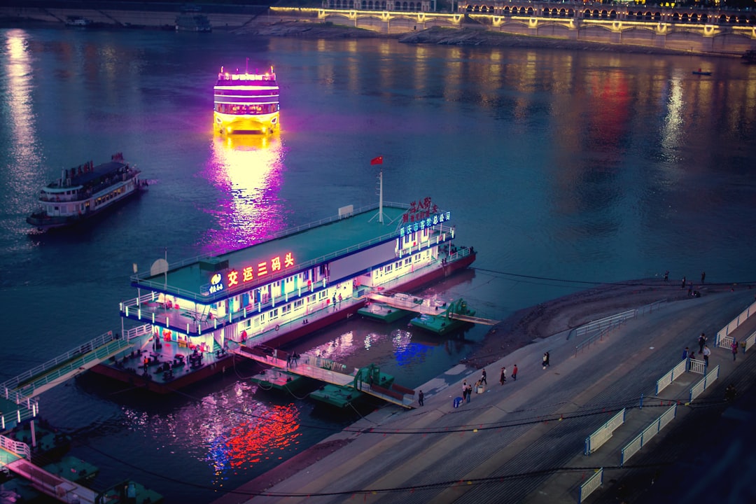 a large boat floating on top of a river next to a pier,