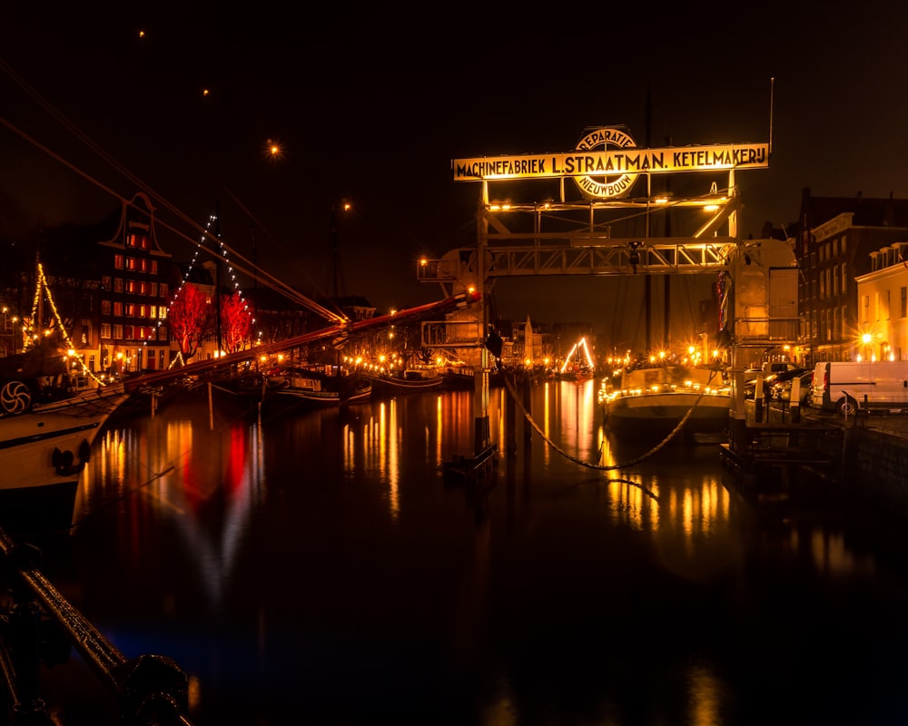 a night scene of a harbor with boats and lights