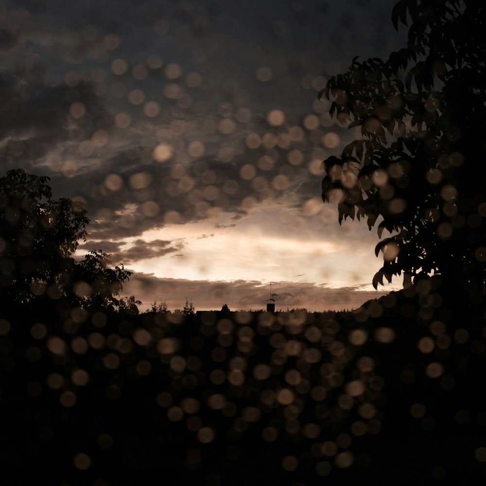 a view of a cloudy sky through a rain covered window