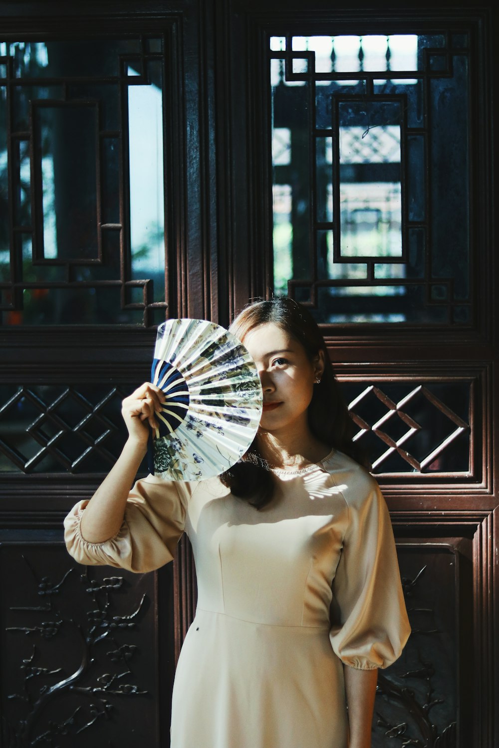 a woman in a white dress holding a fan