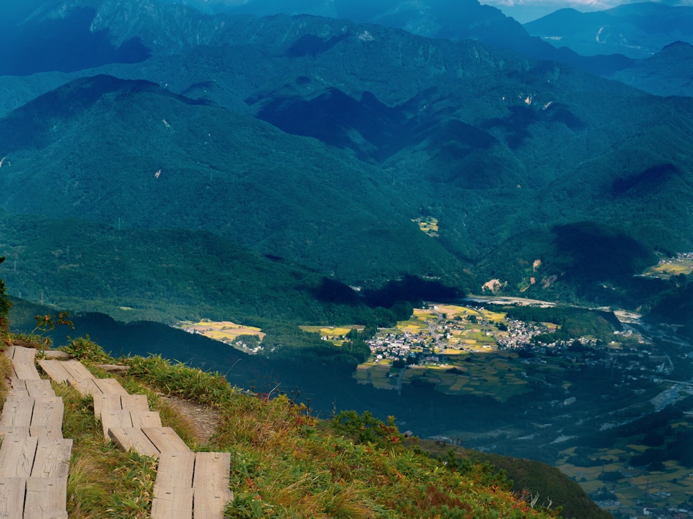 a scenic view of a valley and mountains from the top of a hill