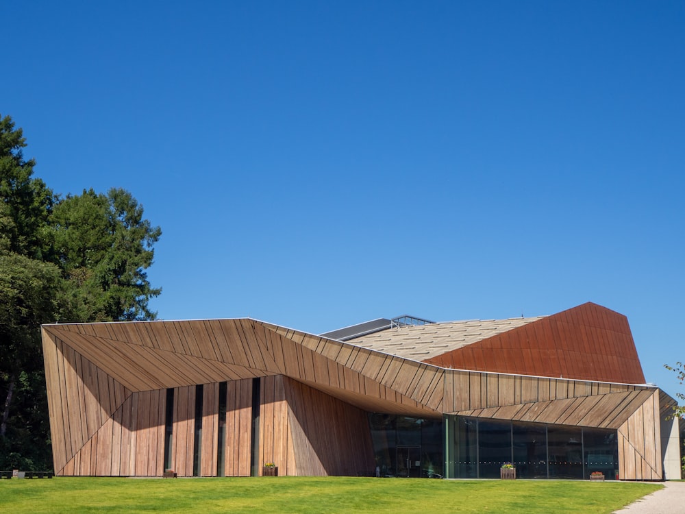 a large building with a curved roof on top of a lush green field