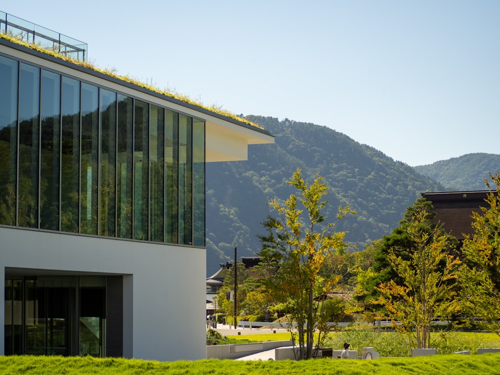 a building with a green roof and a mountain in the background