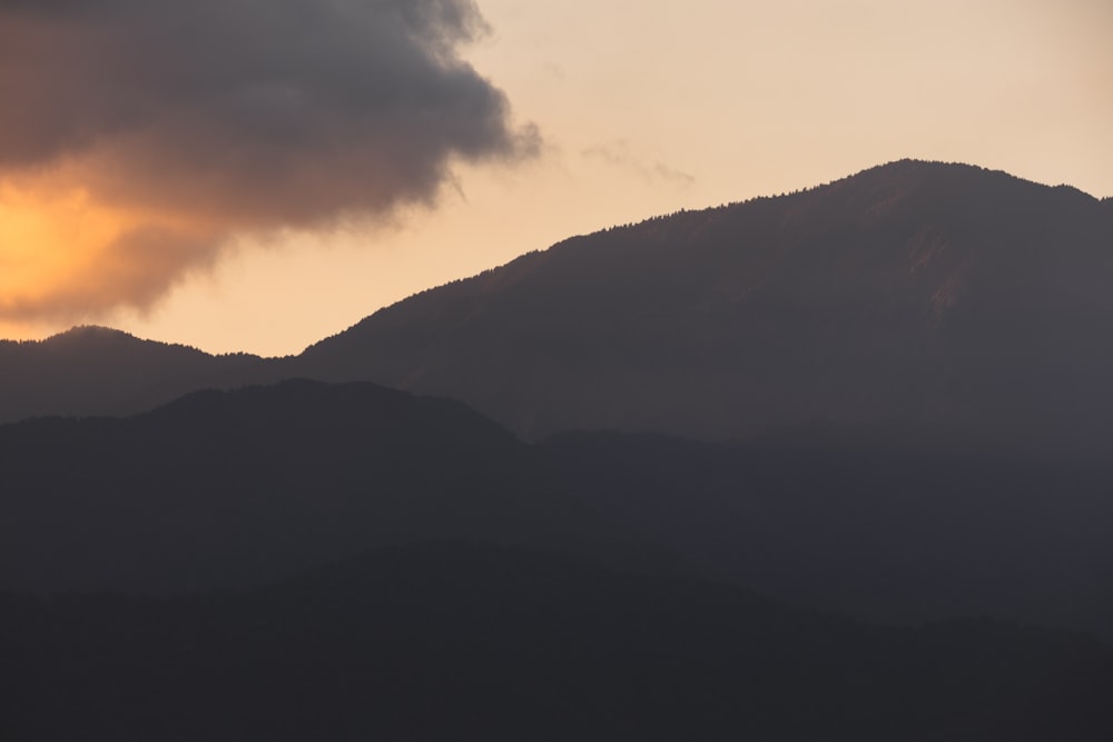 Le soleil se couche derrière une chaîne de montagnes