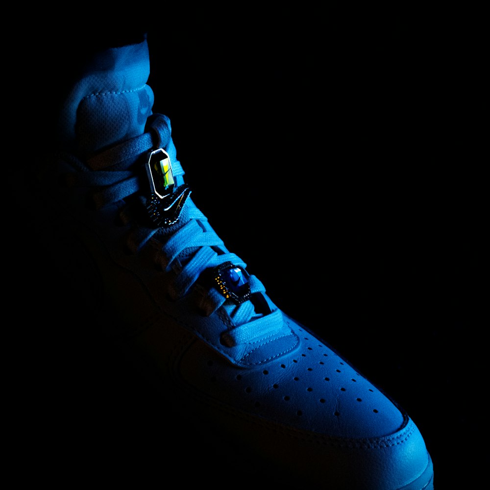 a pair of blue sneakers with a black background