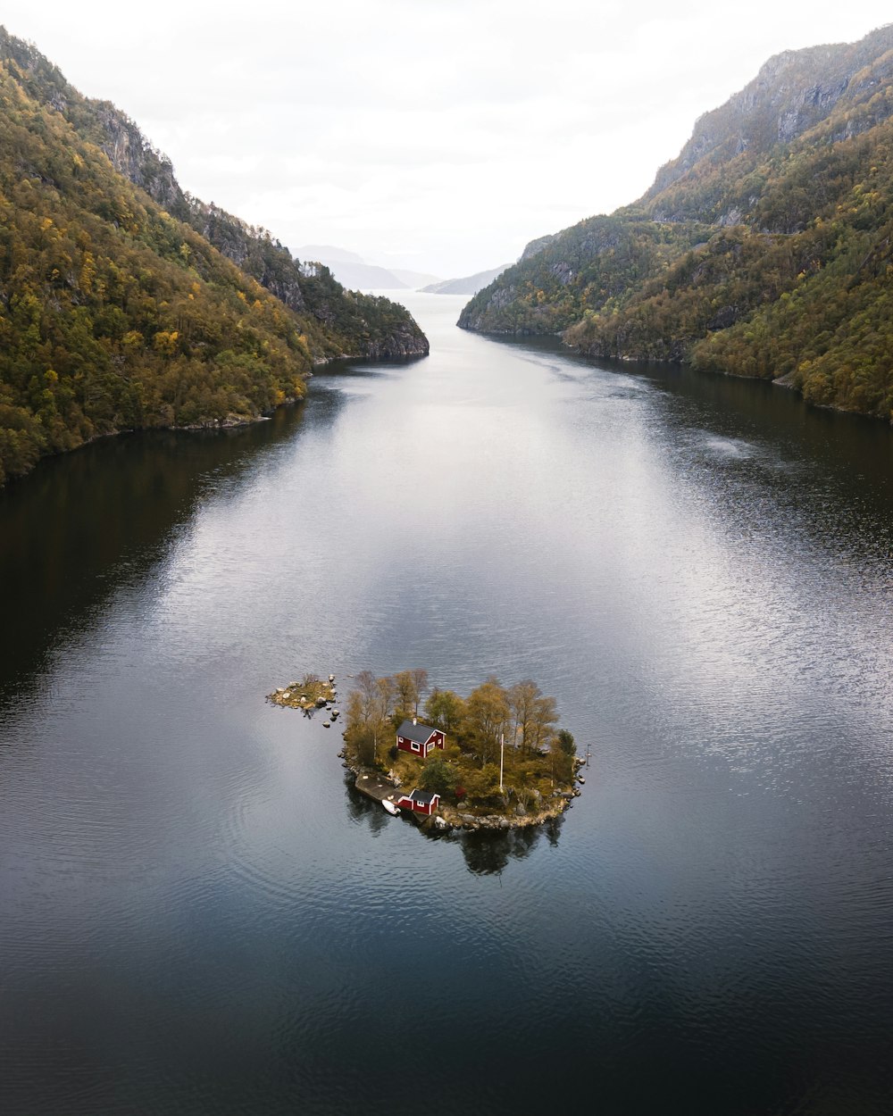 an island in the middle of a lake surrounded by mountains