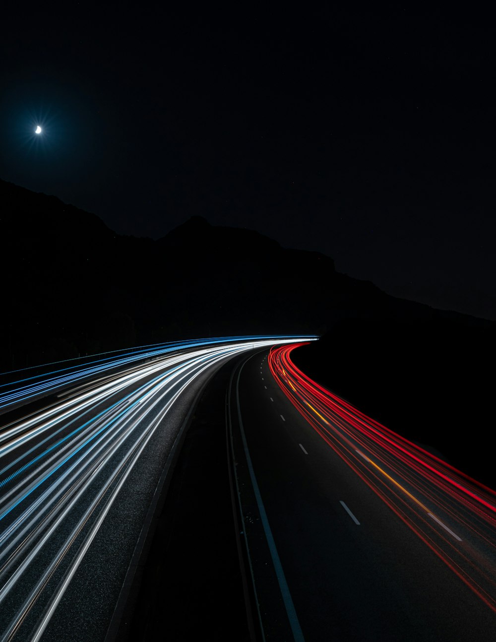 a long exposure photo of a highway at night