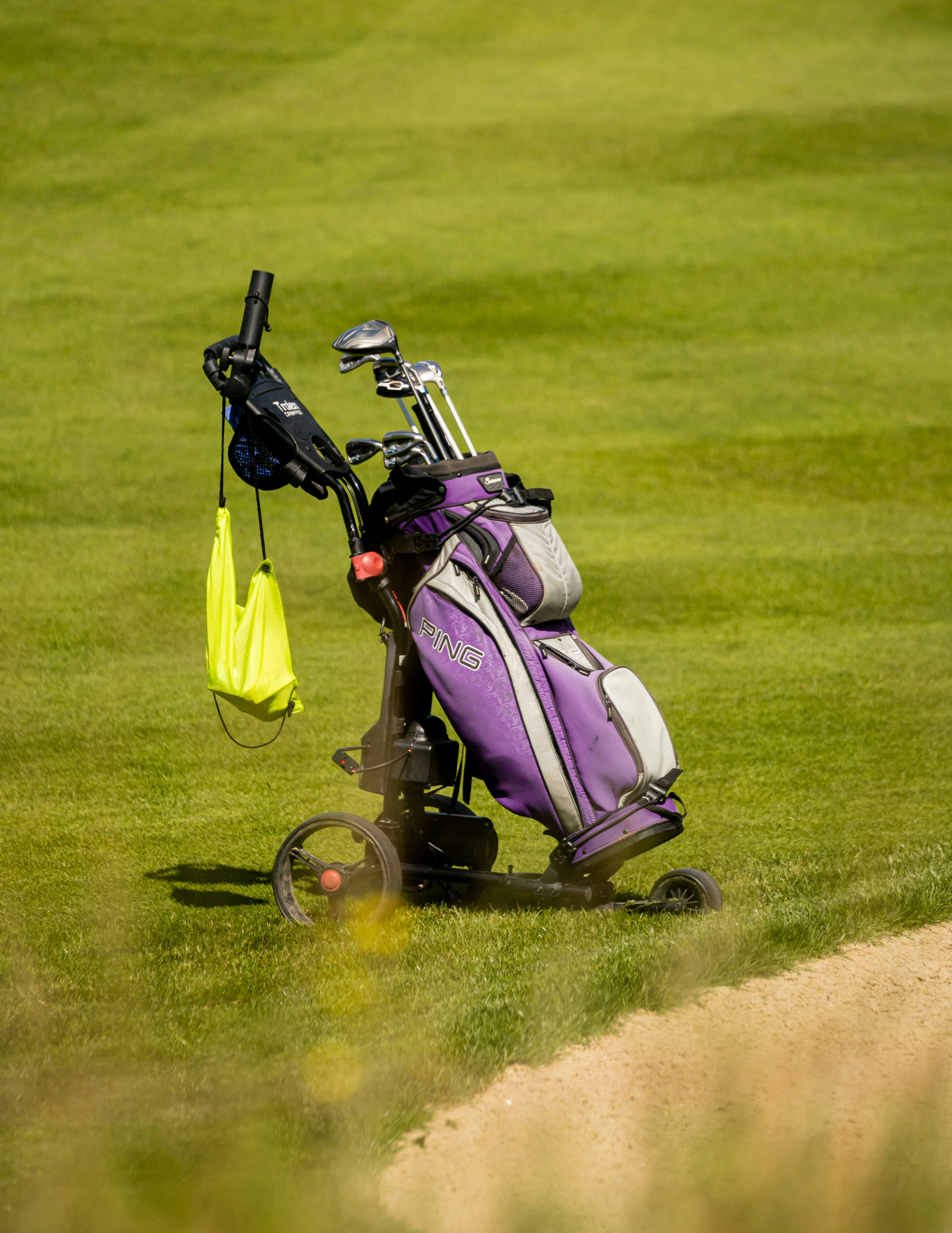 a purple golf cart with a golf bag on it