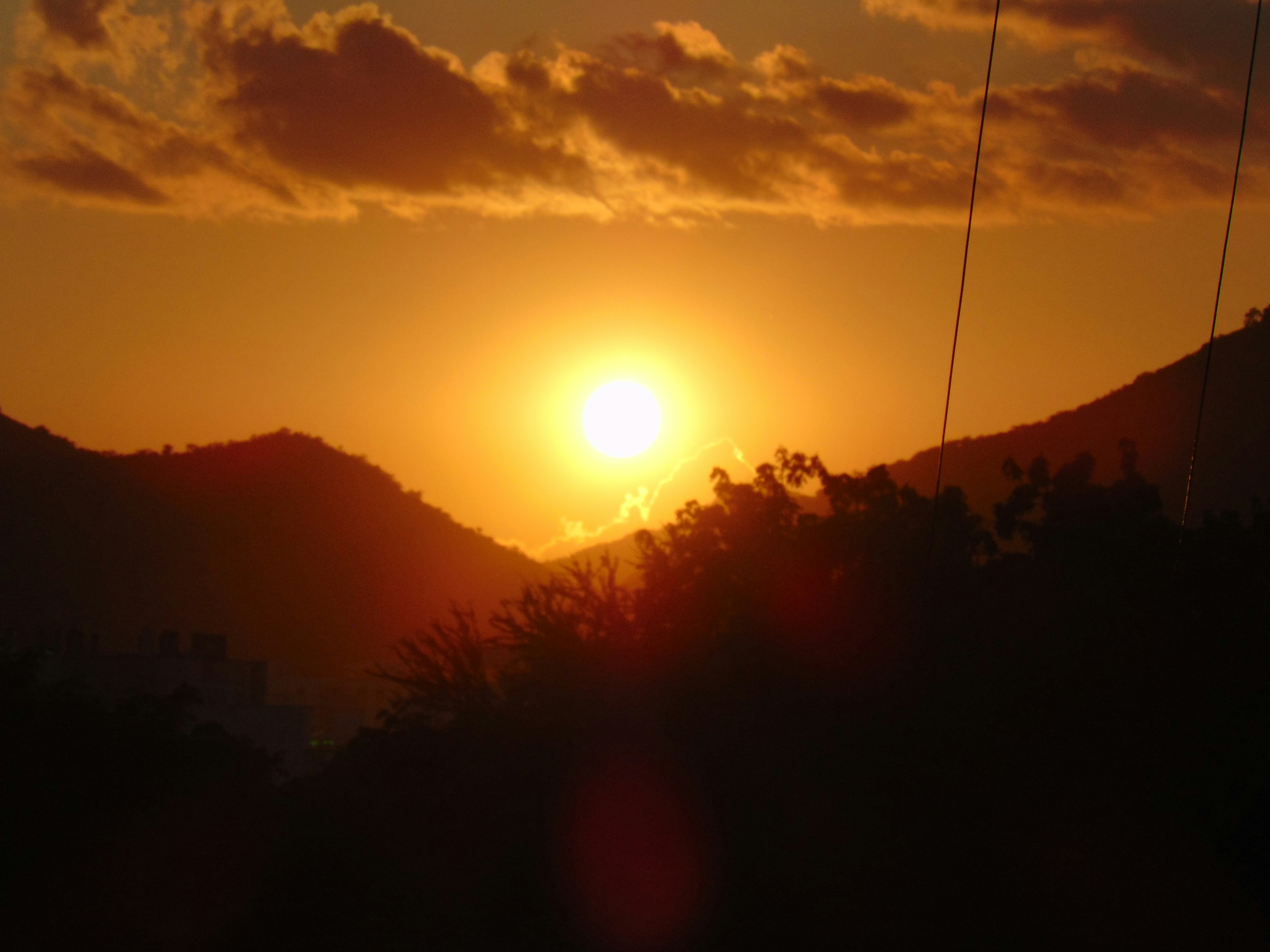 the sun is setting over a mountain range