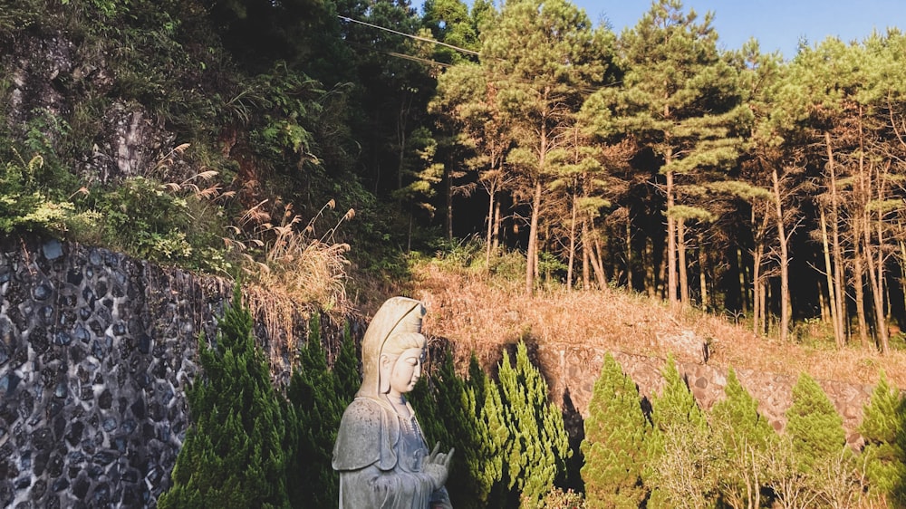 a statue of a person in a forest