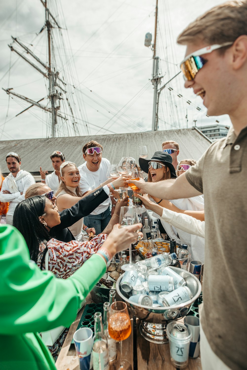 a group of people standing around a table filled with drinks