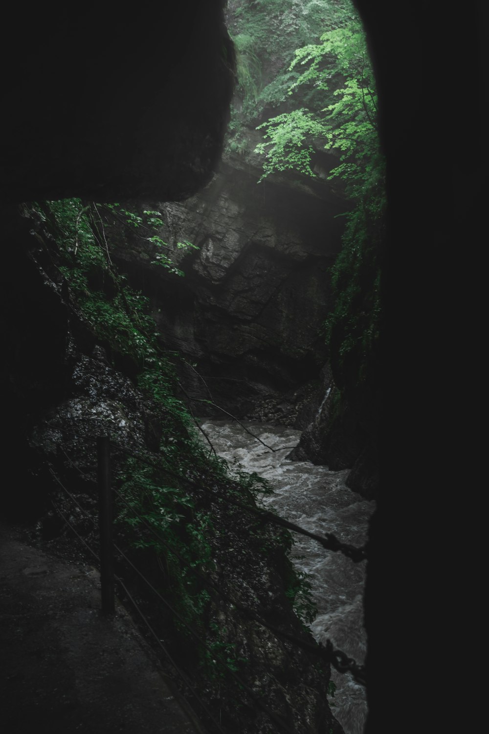 a dark cave with a stream running through it