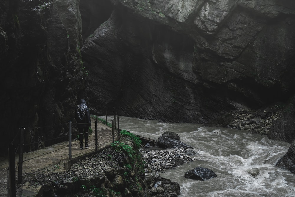 a man standing on a bridge over a river