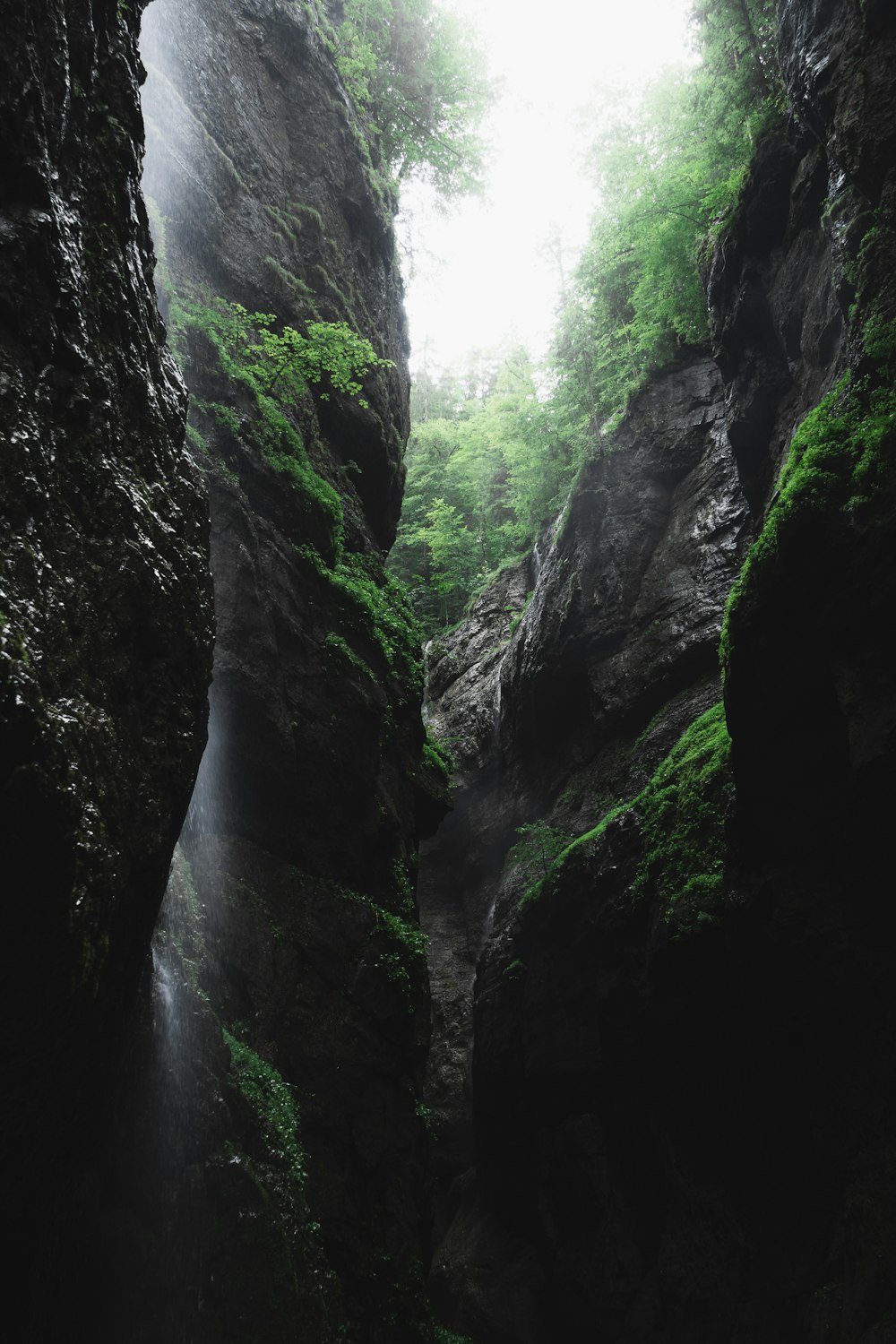 a narrow canyon with a waterfall in the middle of it