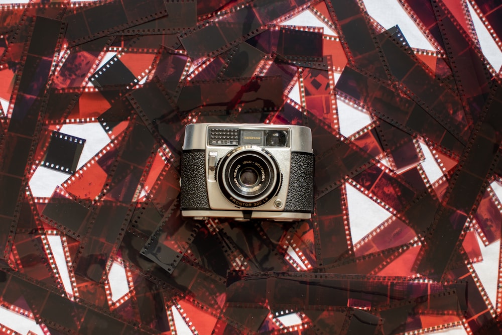 una macchina fotografica seduta sopra un tavolo coperto di strisce di pellicola