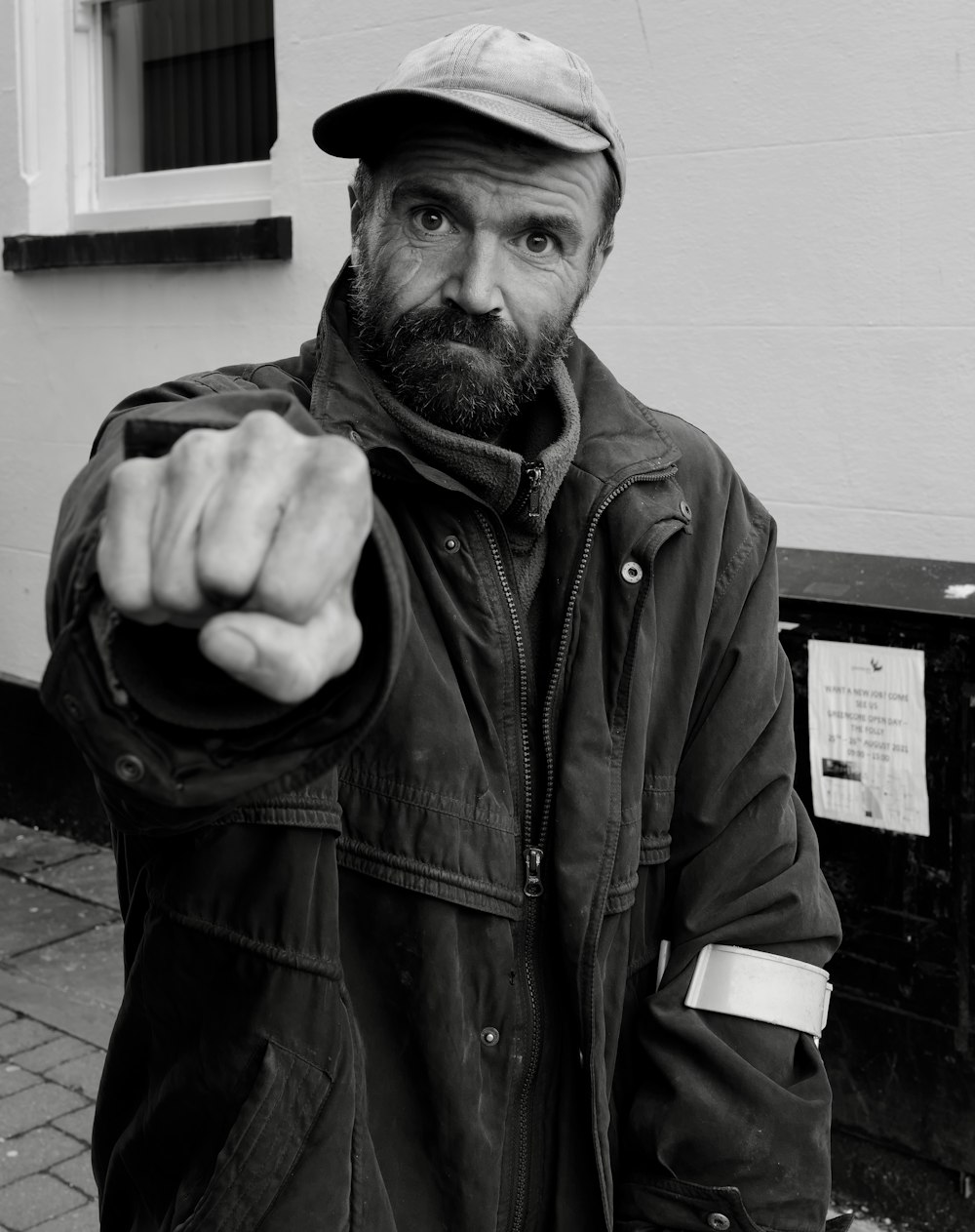 a man pointing at the camera with a hat on