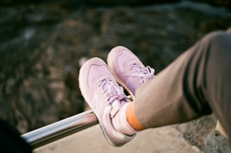 a person sitting on a railing with their feet up
