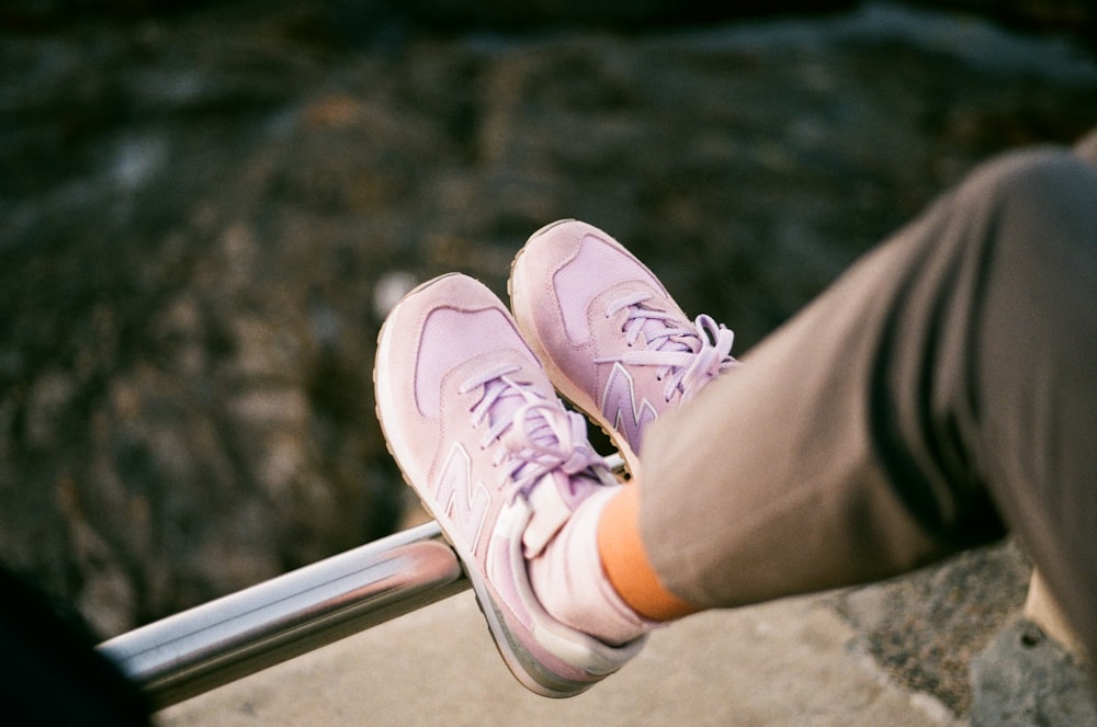 a person sitting on a railing with their feet up