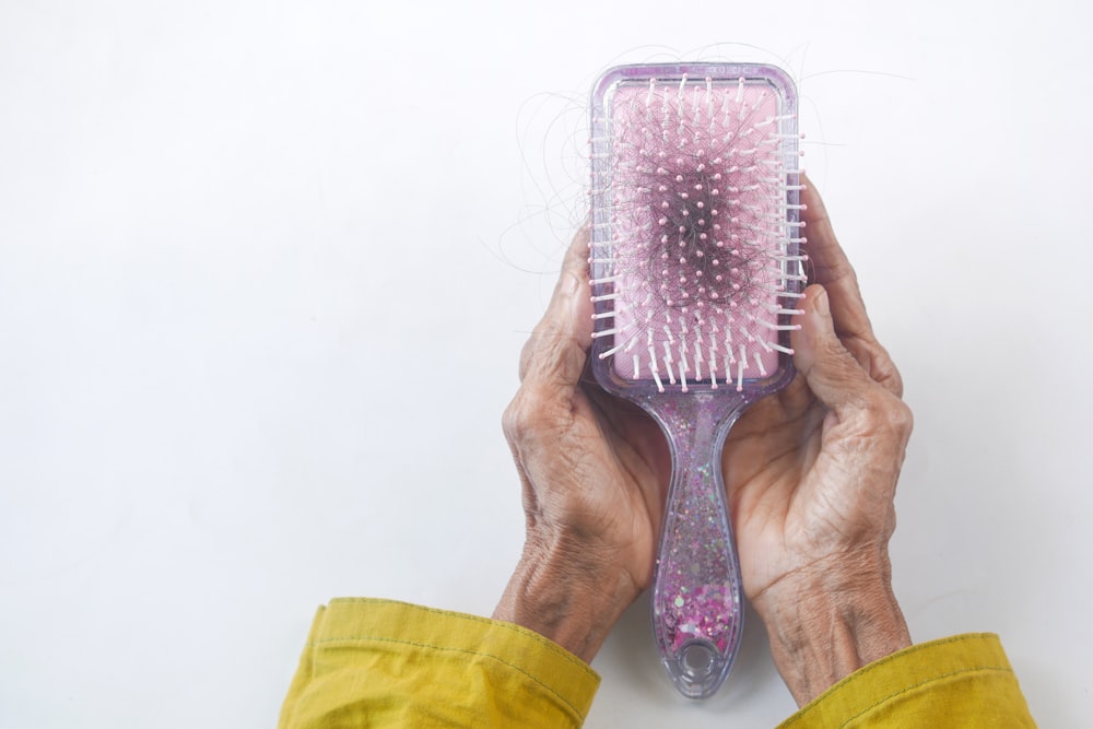 a person holding a hair brush in their hands