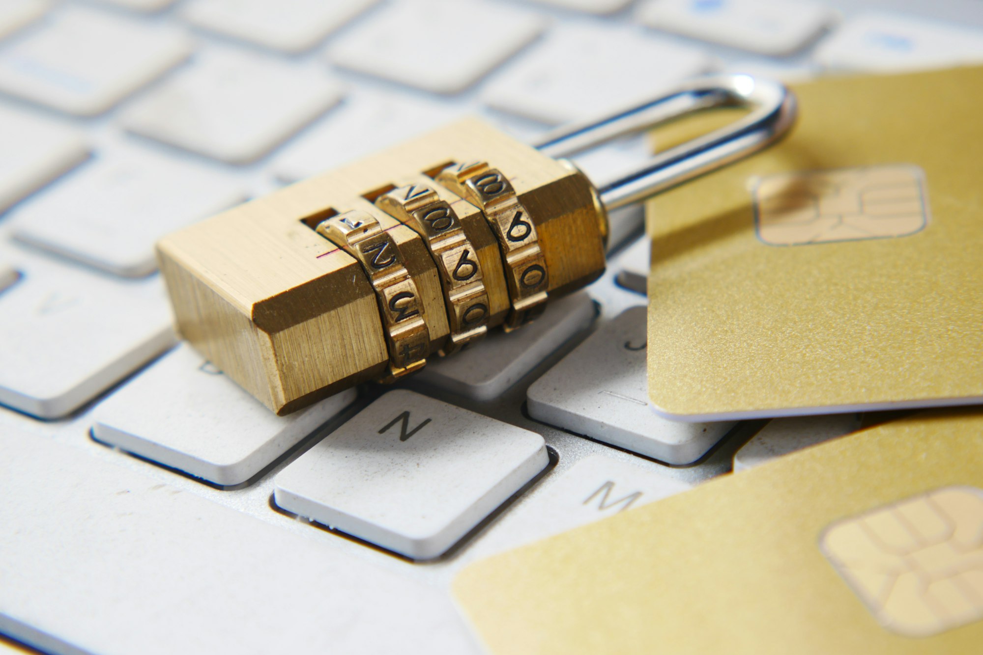 a stock photo of a combinatino lock laying on a laptop keyboard