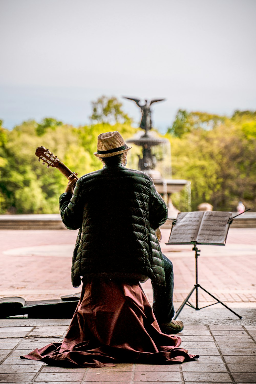 a man sitting on a bench playing a guitar