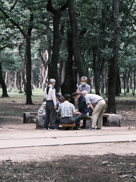 A lively photo of elderly white people laughing together while engaging in cognitive exercises around a table.