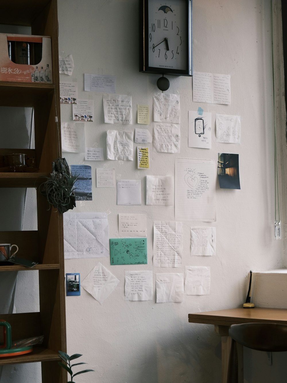 a room with a clock and a bunch of papers on the wall