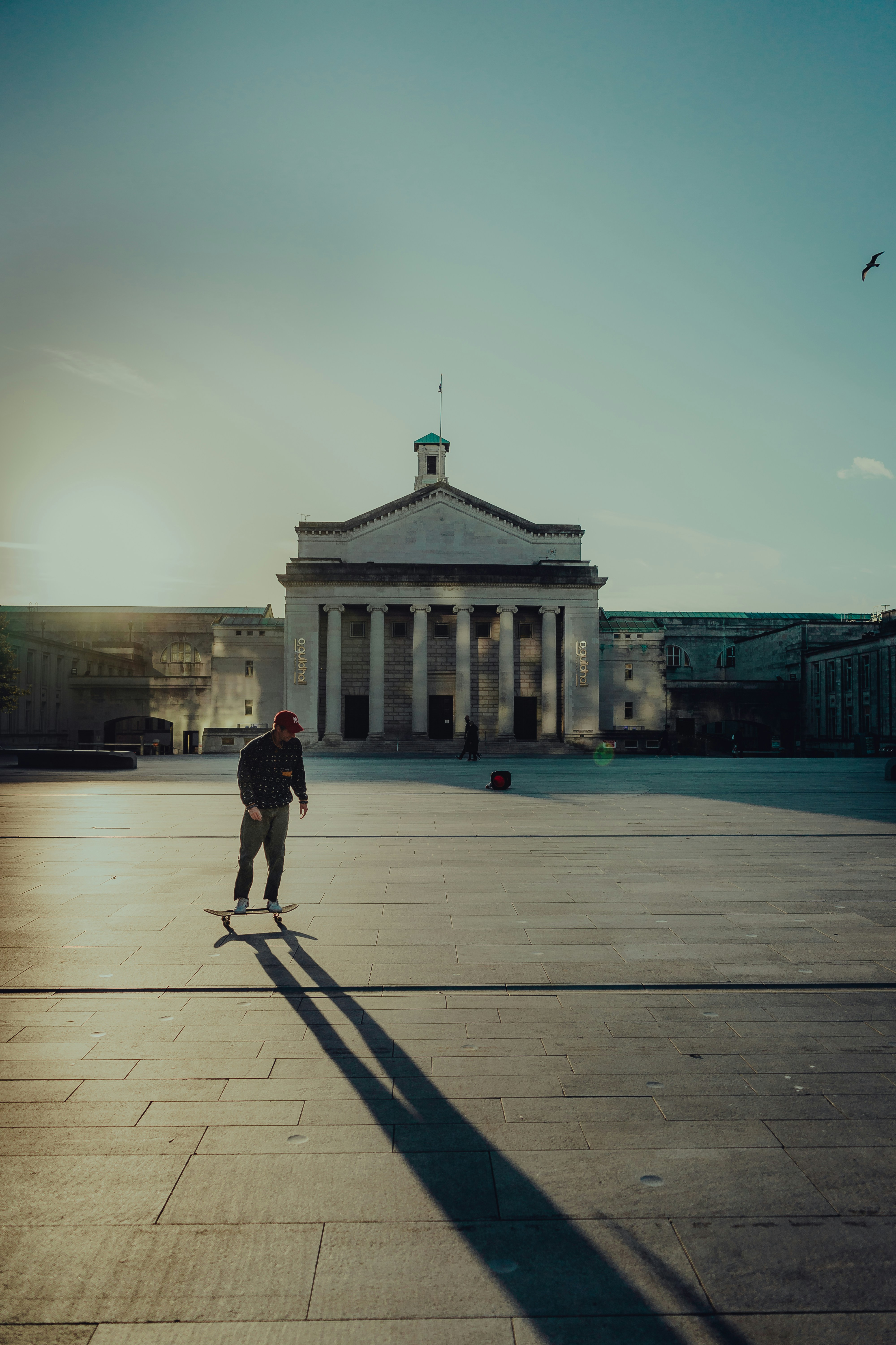 a man riding a skateboard across a parking lot