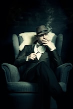 a man sitting in a chair smoking a cigarette