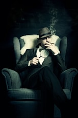 a man sitting in a chair smoking a cigarette