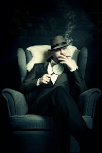 a man sitting in a chair smoking a cigarette