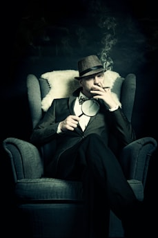 a man sitting in a chair smoking a cigarette