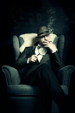 a man sitting in a chair smoking a cigarette