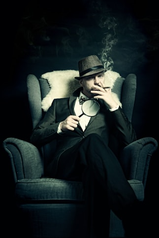 a man sitting in a chair smoking a cigarette