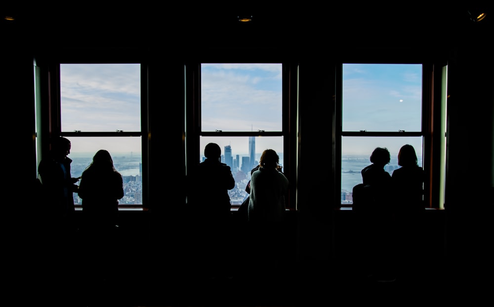 a group of people standing in front of a window