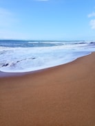 A serene beach with gentle waves and golden sand.