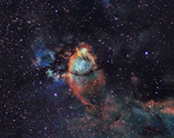 Close-up image of a colorful nebula illuminated by nearby stars.