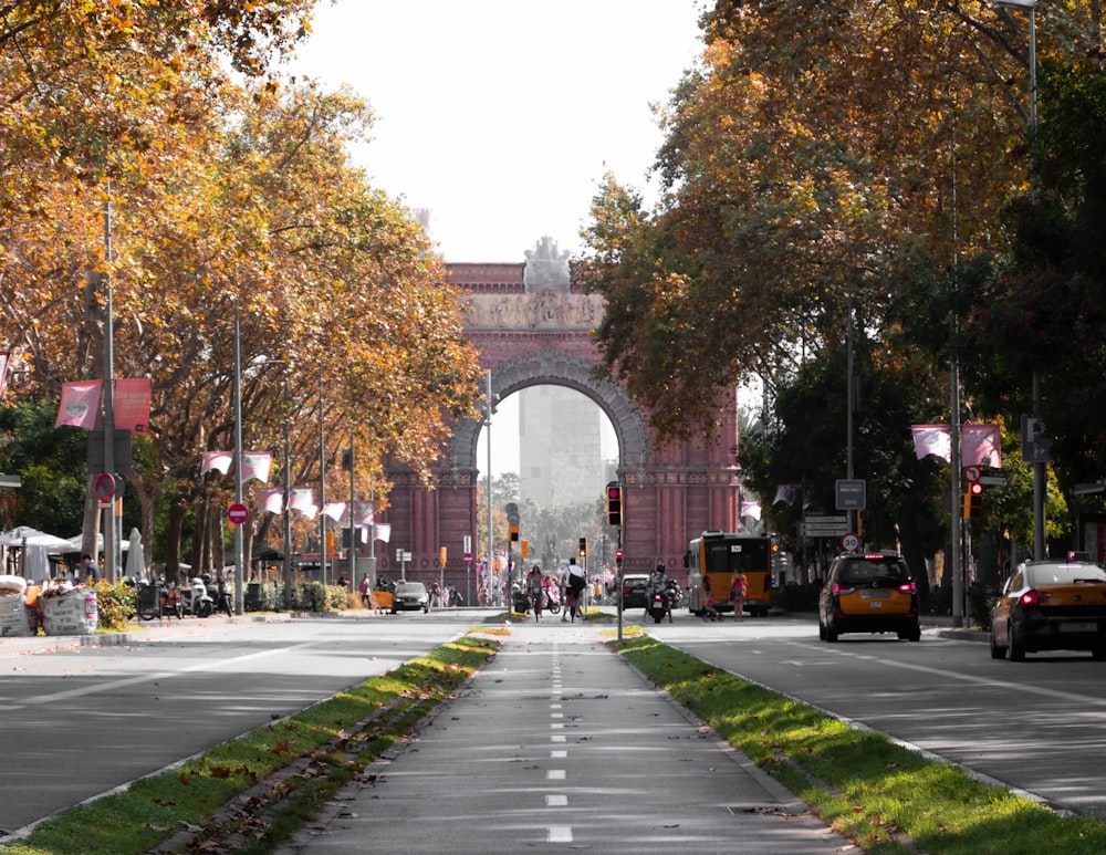 a city street with a large arch in the background