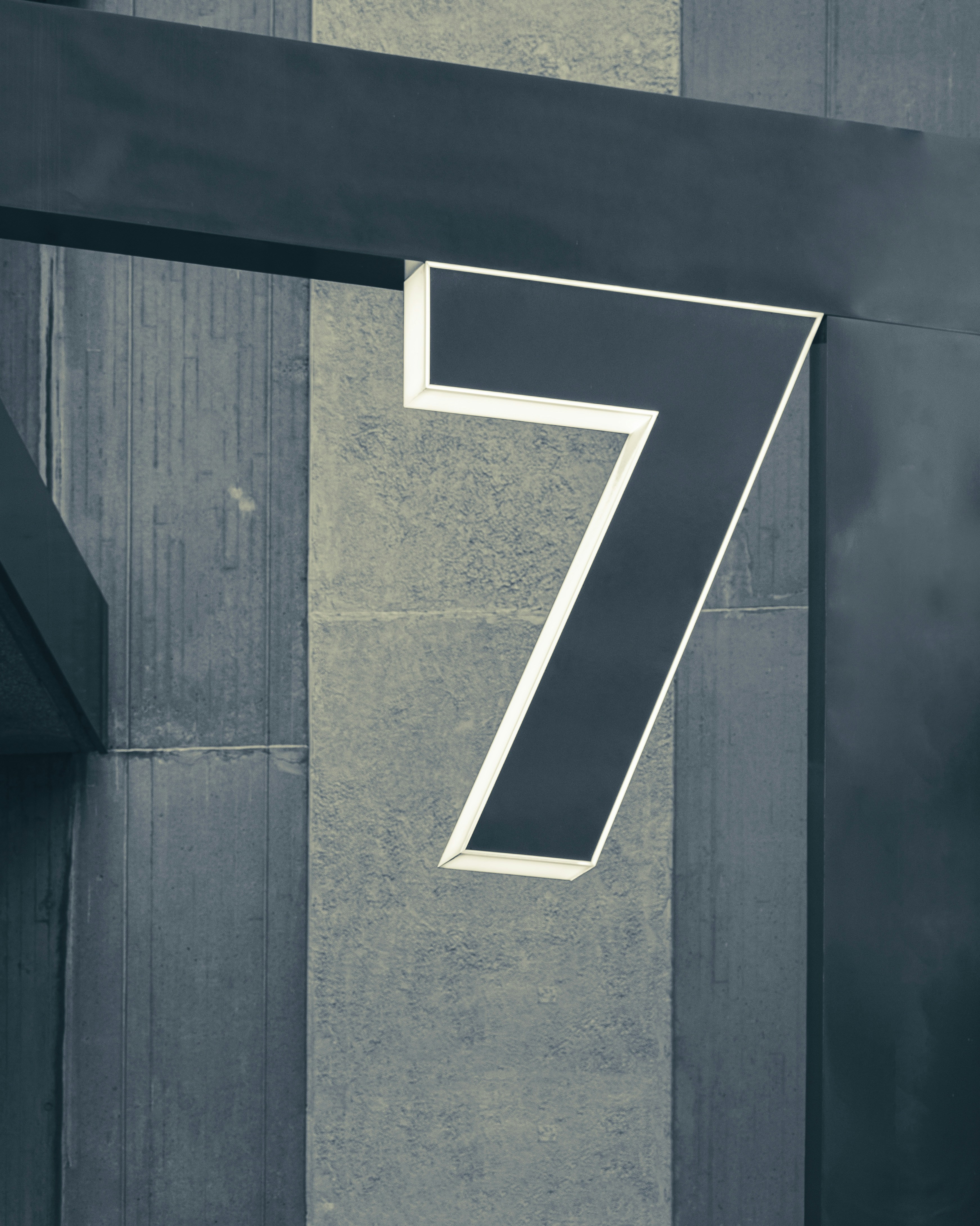 Number 7 signage on a concrete and metal wall.