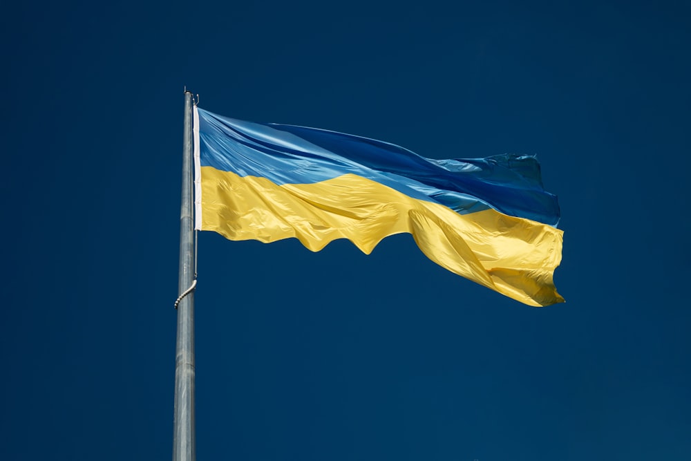 the flag of ukraine is flying high in the sky