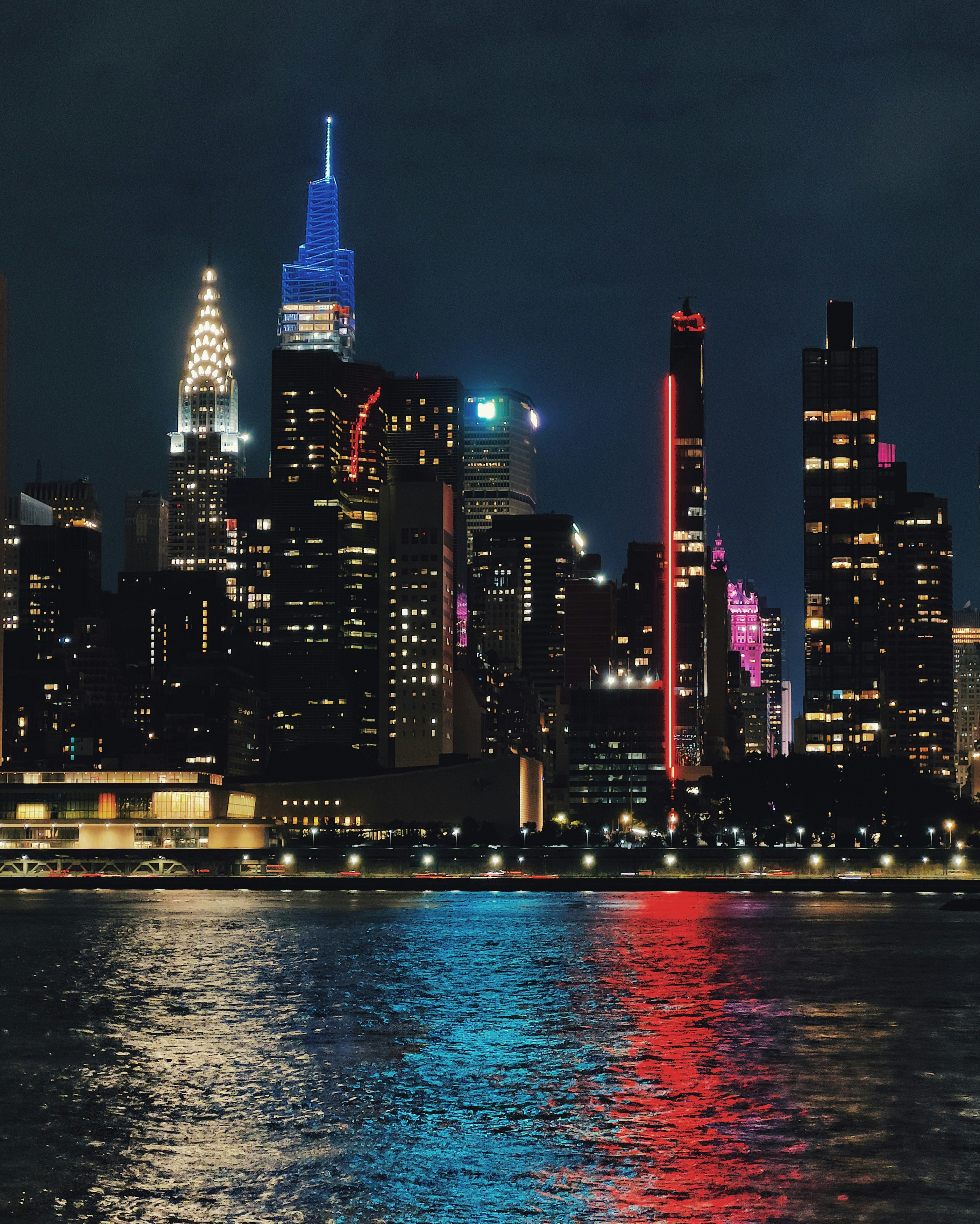 Uno skyline della città di notte con luci che si riflettono sull'acqua