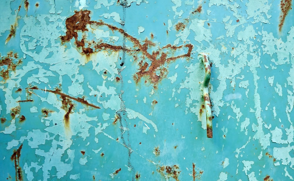 a rusted metal surface with blue paint