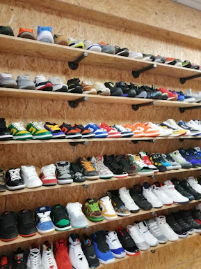 A vibrant collection of sneakers arranged neatly on a white shelf, showcasing their trendy designs and colors.