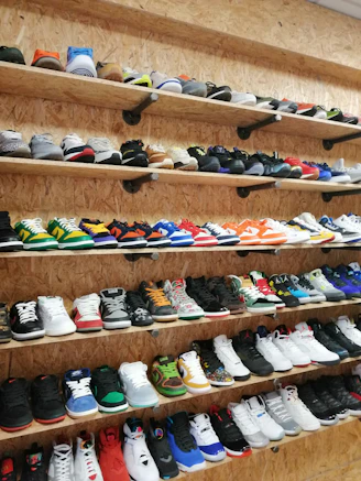 A vibrant collection of sneakers arranged neatly on a white shelf, showcasing their trendy designs and colors.